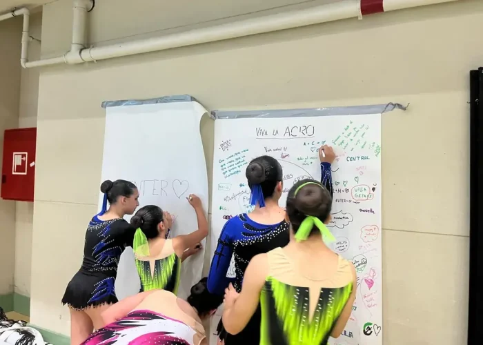 Gimnastas del club firmando el mural Viva la Acro en una competición